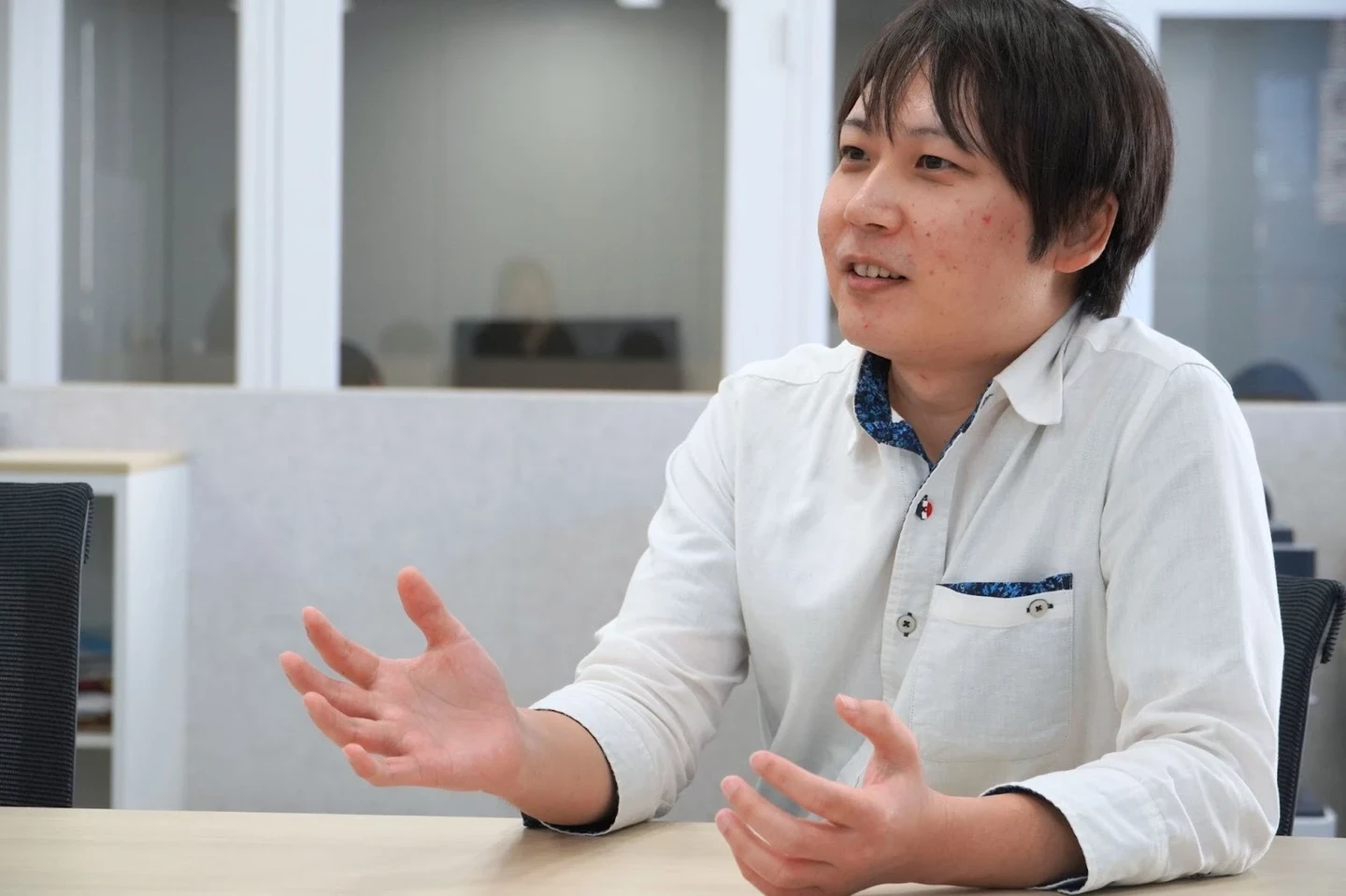 手振りを交えて説明する若手男性社員（玉利さん）